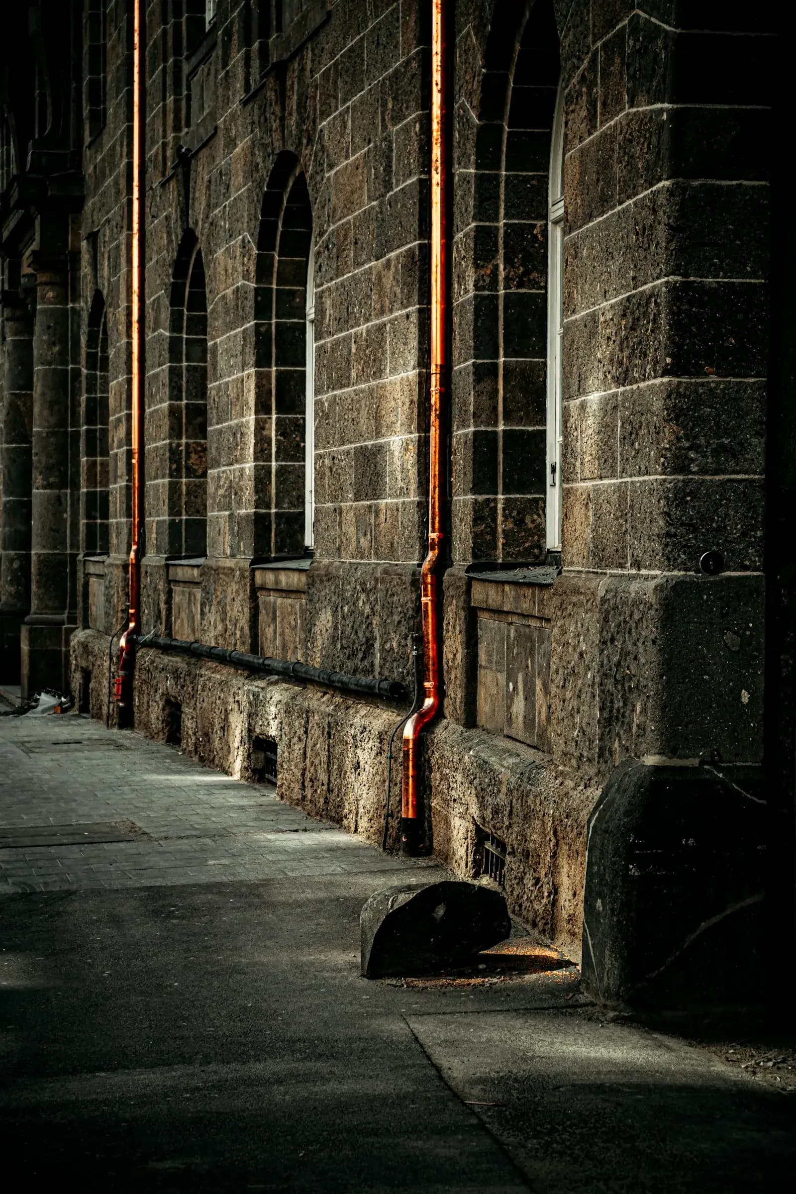 Copper pipework running down a stone facade